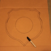 Trace your cut out plaque on another piece of cardboard. Then draw a margin of around 1/2" inside the plaque.