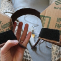 Next, firmly pull the felt strips around the underside of your headband and hot glue to cardboard so there is no slack